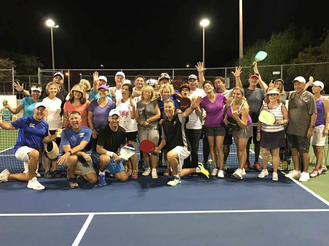 The whole camp group celebrating together on court after an evening session